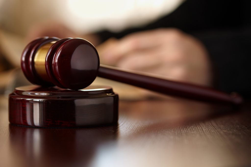 Gavel in front of judge's hands as they review information from a Camp Pendleton Military Defense Law Firm